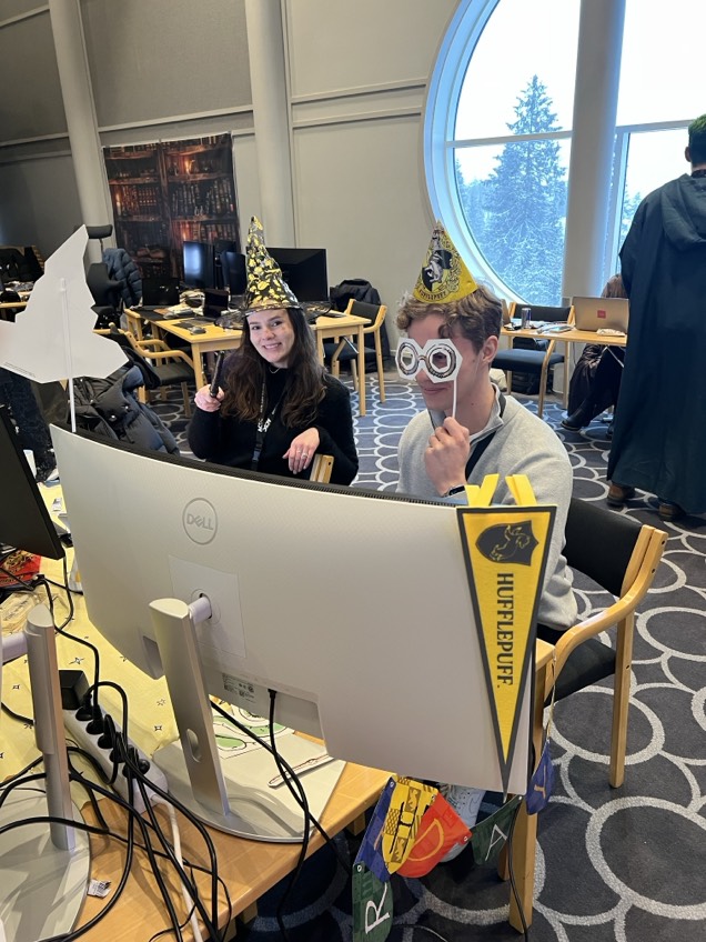 Mari with a wand and Ludvig coding with glasses, and our Hufflepuff house pennant